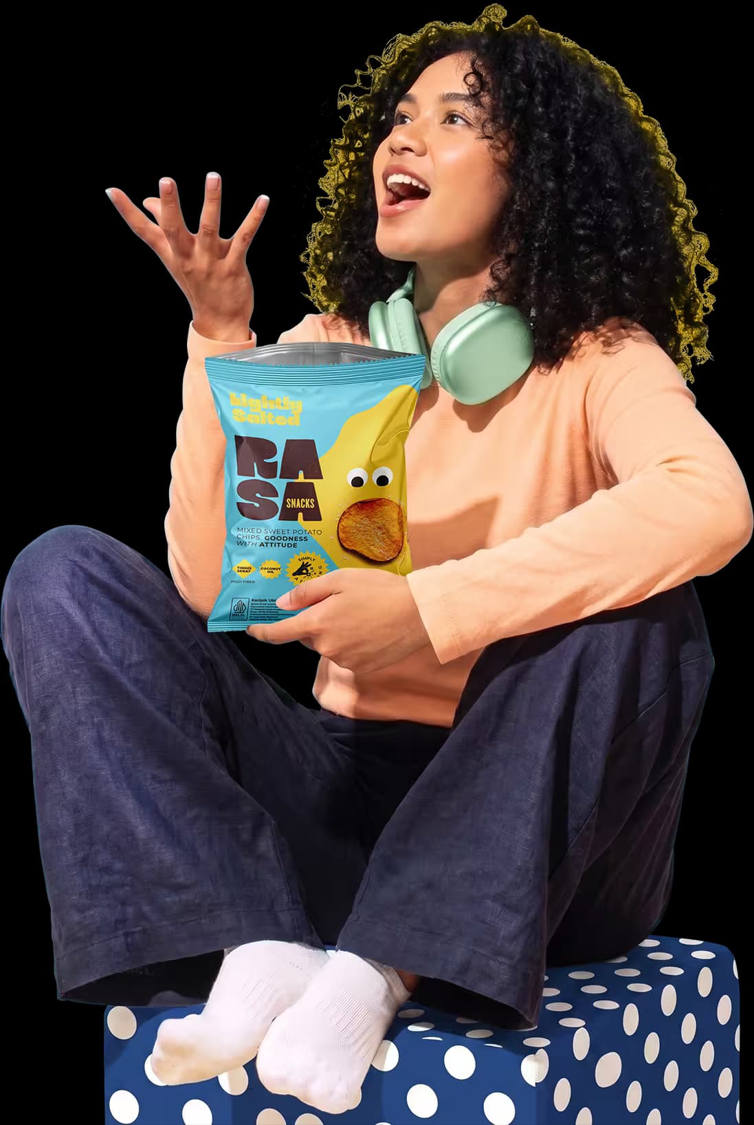 Perempuan tertawa sambil memegang RASA Chips dan melempar keripik ubi