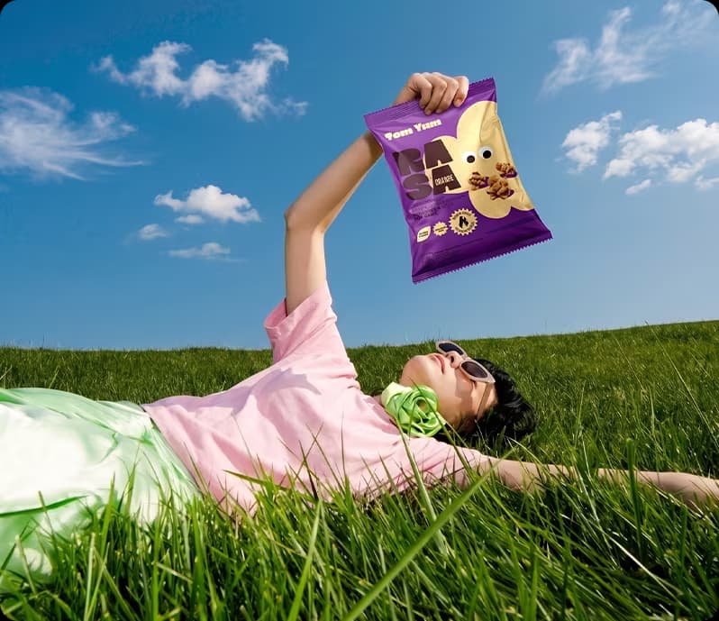Perempuan rebahan di rumput mengangkat RASA Tom Yum
